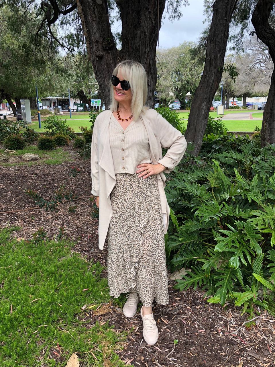 Blond woman wearing animal print maxi skirt and oatmeal top and jacket from the post how to wear long skirts without looking frumpy.