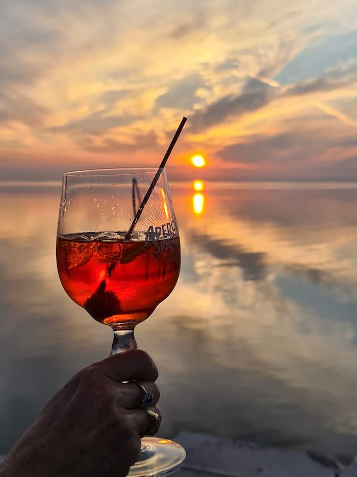 Aperol Spritz against a sunset in Italy