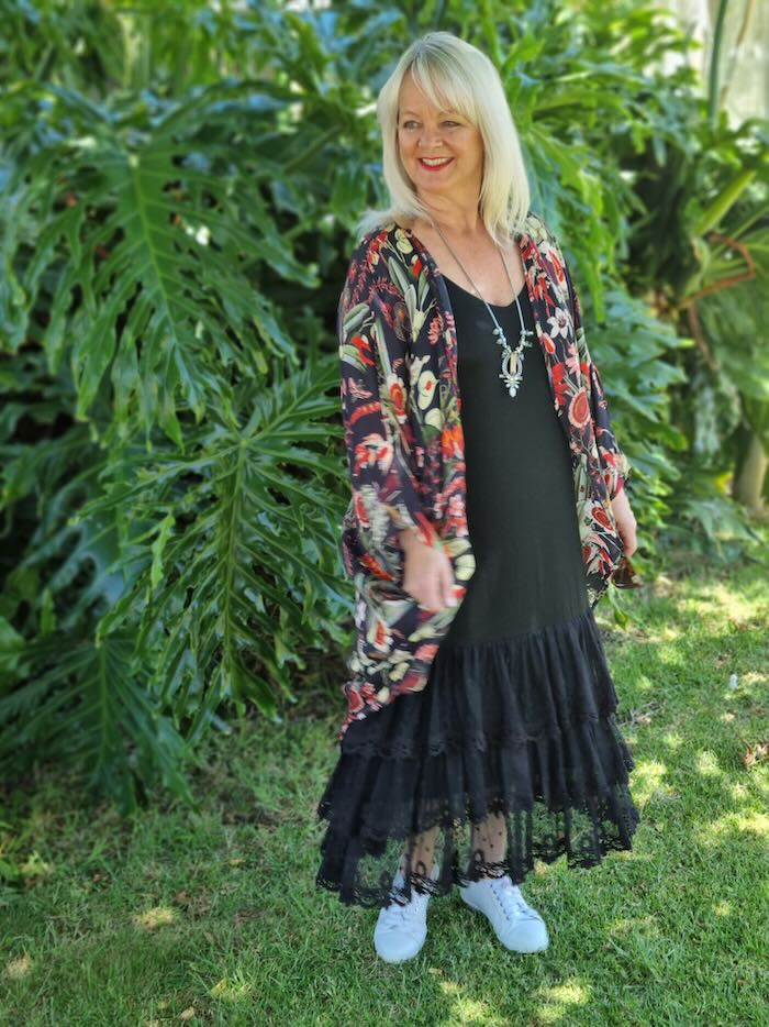 Blond woman wearing a black summer dress with a kimono
