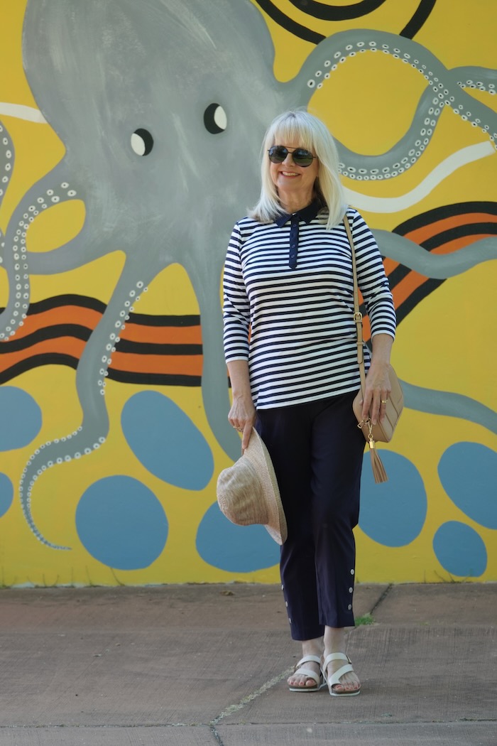 Woman wearing classic blue and white clothes and sandals that are suitable for a woman over the age of 60.