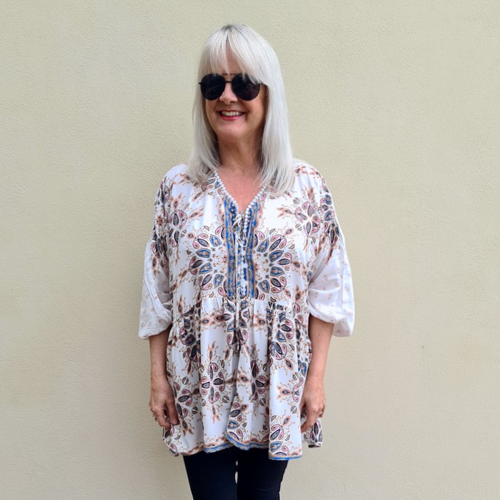 Blond haired woman wearing a boho style blouse to illustrate, and explore the differences between blouses and shirts.