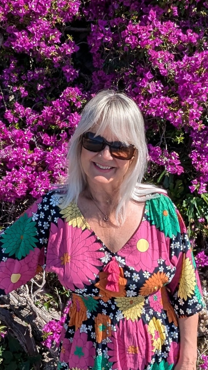 Woman in a summer dress, wearing sunglasses, illustrating what to pack for south of France in May.