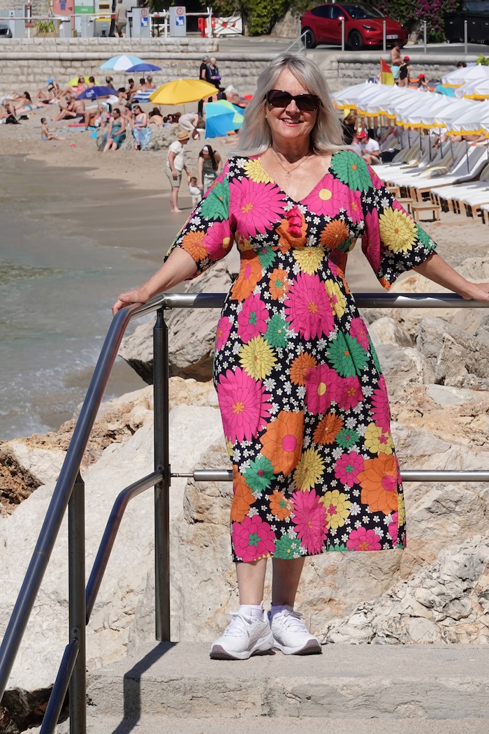 Image of woman over 50 in floral dress suitable for travelling