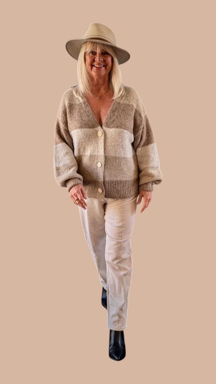 Woman wearing beige and oatmeal coloured cardigan, pants and boho style hat.