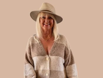 Woman wearing beige hat and stripey cardigan illustrating a boho style outfit