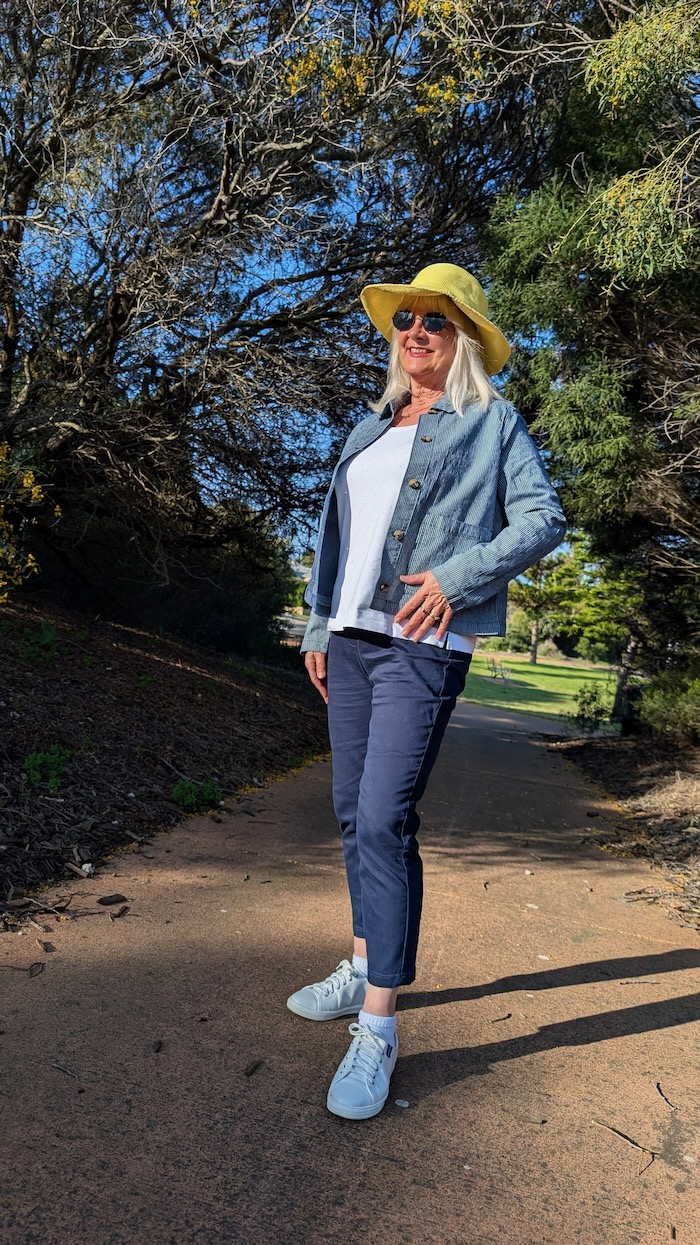 Woman over 60 wearing an outfit suitable for travelling.